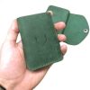 žalia odinė vyriška piniginė laikoma rankoje